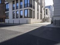 a building is on the side of the street with cobblestone walkway on one side