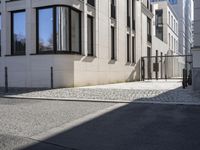 a building is on the side of the street with cobblestone walkway on one side