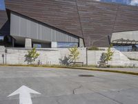 a street arrow pointing up at an outside building where the sky is clear and blue