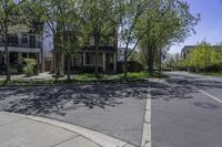 an empty street lined with parked cars and some houses in the background of this photo