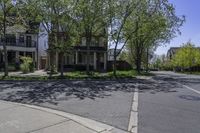 an empty street lined with parked cars and some houses in the background of this photo