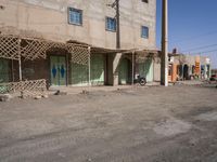 the building is constructed with wooden poles on it's sides and blue doors are also painted on them