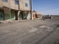 the building is constructed with wooden poles on it's sides and blue doors are also painted on them