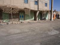the building is constructed with wooden poles on it's sides and blue doors are also painted on them