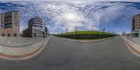 an image of a distorted fisheye lens showing some buildings on the street and a park