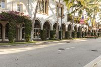 this is a row of palm trees in the front of a large building that looks like an old town