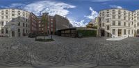 some buildings are seen in this 360 camera image, a very big, large brick and stone building