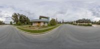 a view of the street from outside of an empty residential complex with concrete, grass and other shrubbery