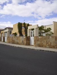 this residential complex has large tan colored stucco fences and beige - faced walling to the sides