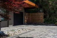 the patio has stone pavers in it and green trees behind it for privacy from the sun