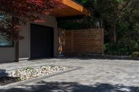 the patio has stone pavers in it and green trees behind it for privacy from the sun