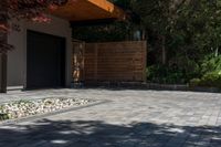 the patio has stone pavers in it and green trees behind it for privacy from the sun