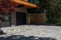 the patio has stone pavers in it and green trees behind it for privacy from the sun