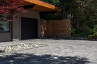 the patio has stone pavers in it and green trees behind it for privacy from the sun