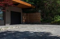 the patio has stone pavers in it and green trees behind it for privacy from the sun