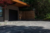 the patio has stone pavers in it and green trees behind it for privacy from the sun