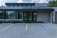 a building with an entrance that has a sign on it in front of it that says presentation gallery