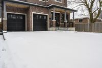 a large brown brick home in the snow with trees in front of it and the driveway covered with snow
