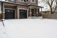 a large brown brick home in the snow with trees in front of it and the driveway covered with snow