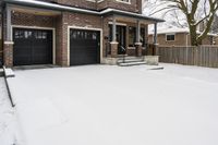 a large brown brick home in the snow with trees in front of it and the driveway covered with snow