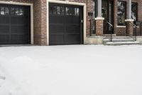 a large brown brick home in the snow with trees in front of it and the driveway covered with snow