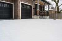 a large brown brick home in the snow with trees in front of it and the driveway covered with snow
