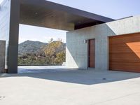 a gray concrete building with stairs and door at the top of the floor next to it is steps leading down to the doorway