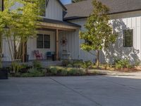 an open - concept home with a garage and attached porch area at the corner of a street