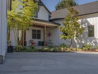 an open - concept home with a garage and attached porch area at the corner of a street