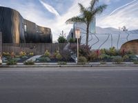 the car is parked on the side of the street with the building behind it and two trees by the side