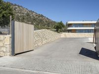 a wooden fence around a driveway gate and entrance way in the mountains near a residential