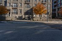 a yellow fire hydrant standing in the middle of a street near several multi - story buildings