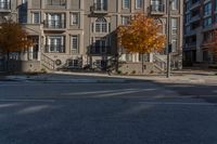 a yellow fire hydrant standing in the middle of a street near several multi - story buildings