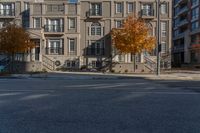 a yellow fire hydrant standing in the middle of a street near several multi - story buildings