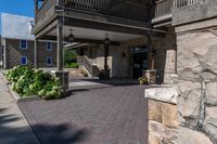 a building has red brick walkway, a stone wall, and two story porches