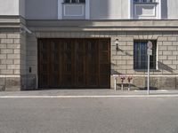 a building with brown doors and two parking meters in front of it along with the sidewalk