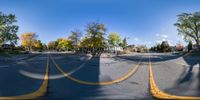 a street view of houses and trees on the corner of the road, from a perspective into the street