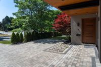 a view of a house with a wood front door and large pavers on the side walk