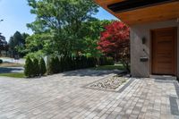 a view of a house with a wood front door and large pavers on the side walk