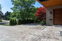 a view of a house with a wood front door and large pavers on the side walk