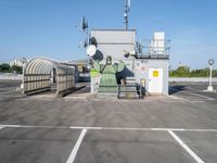 a large factory sitting on top of a metal fence with a light pole and roof