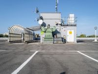 a large factory sitting on top of a metal fence with a light pole and roof