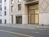 a woman is riding her motorcycle past the building's entrance and entryway and there is also no parking at all