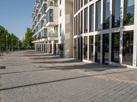 a sidewalk is lined with brick bricks and large windows and doors that lead to some buildings