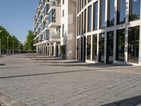 a sidewalk is lined with brick bricks and large windows and doors that lead to some buildings