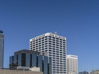 a bunch of high buildings sit near each other on a sunny day and clear blue sky