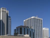 a bunch of high buildings sit near each other on a sunny day and clear blue sky