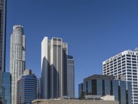 a bunch of high buildings sit near each other on a sunny day and clear blue sky