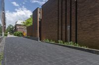 a brick street in the city with trees on the side of the building and a curb with brick pavers in between the buildings