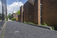 a brick street in the city with trees on the side of the building and a curb with brick pavers in between the buildings